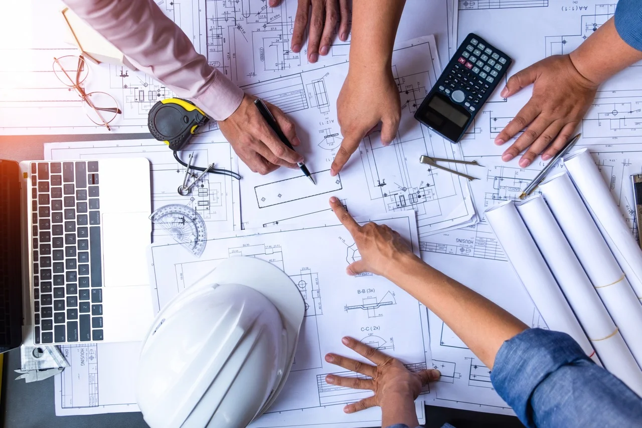 Engineers reviewing construction blueprints and technical drawings